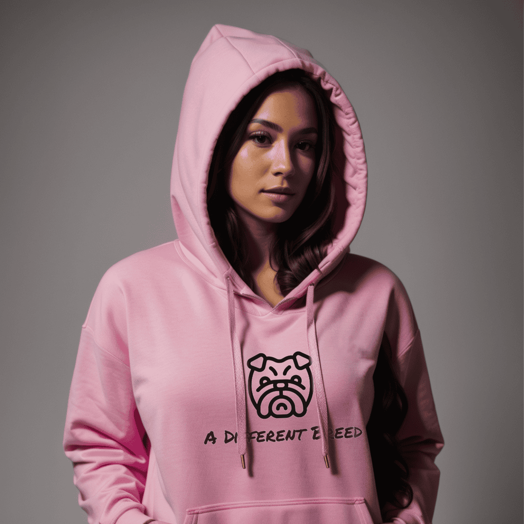 Woman wearing pink hoodie with  a print which reads a different breed across the chest
