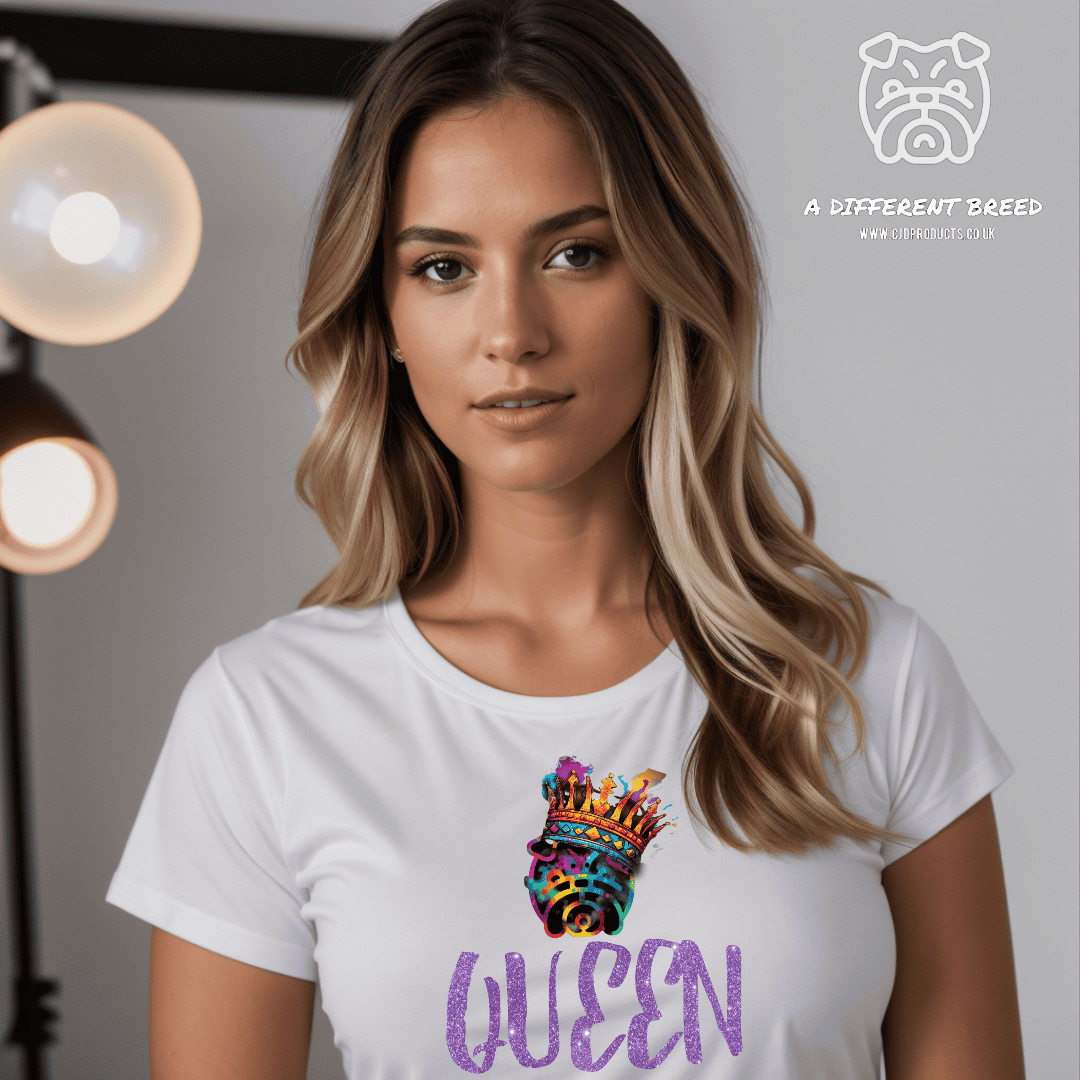 A lady wearing a white t-shirt with the word QUEEN written in a purple text with some sparkles and the a different breed logo in multi colour and wearing a crown place on top of the word queen